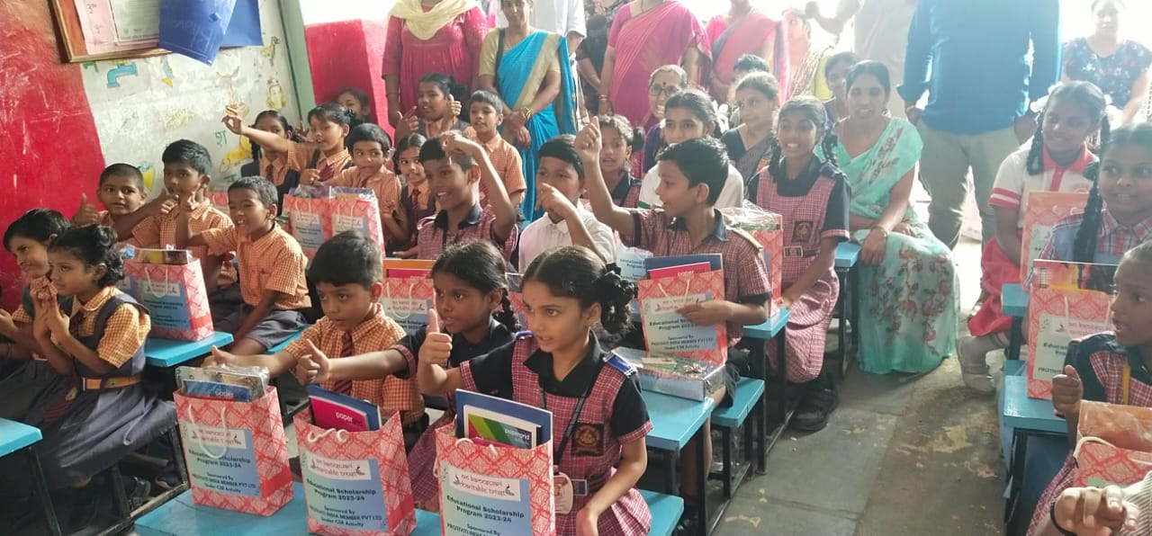 Joyful schoolchildren with their scholarship bags at an Om Kameswari Charitable Trust outreach event