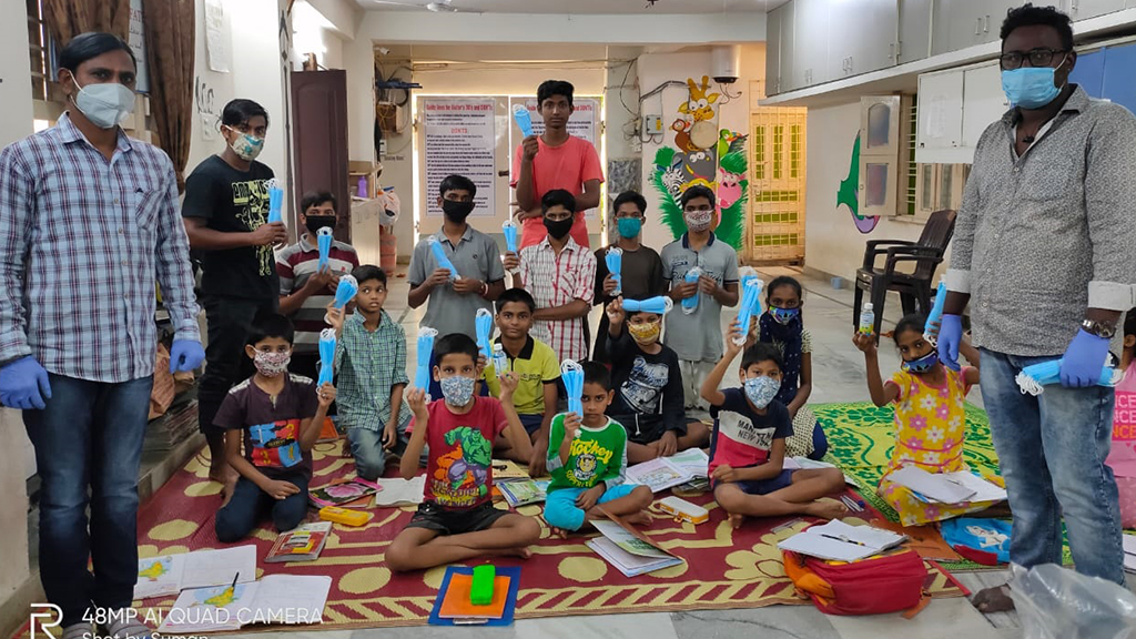 Children seated together receiving hygiene kits at an outreach event